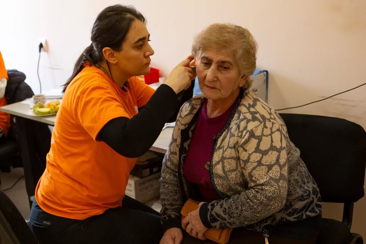 VIVA volunteer examining an older woman during a regional healthcare visit in Armenia