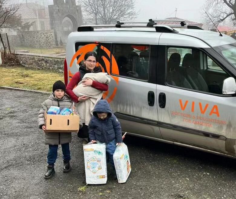 Family receiving medicine and essential supplies beside a VIVA Foundation medical vehicle in Armenia