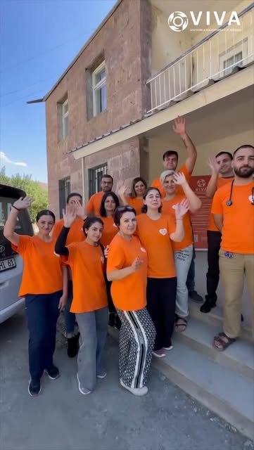 VIVA Foundation doctors and volunteers in orange shirts greeting the camera during regional healthcare outreach in Armenia